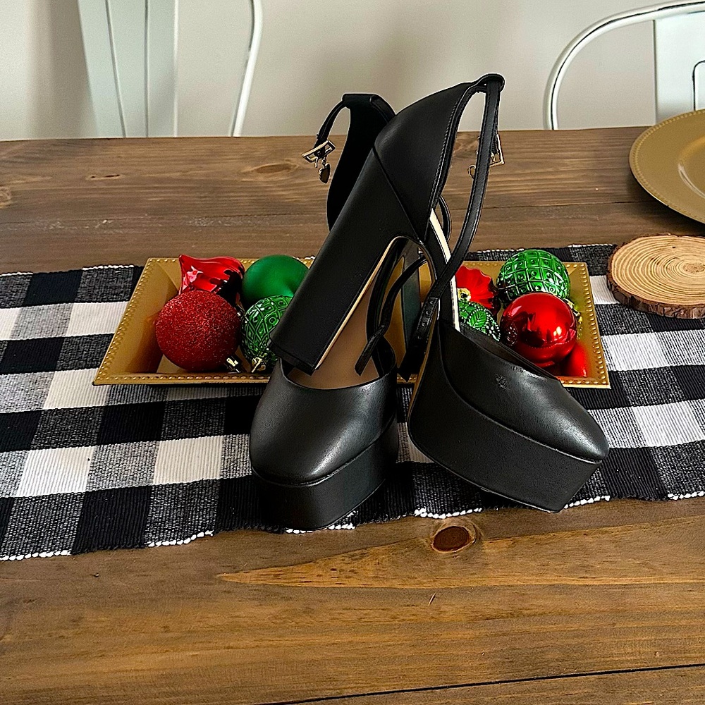 Black Aldo chunky heels with gold heart accent buckle.
